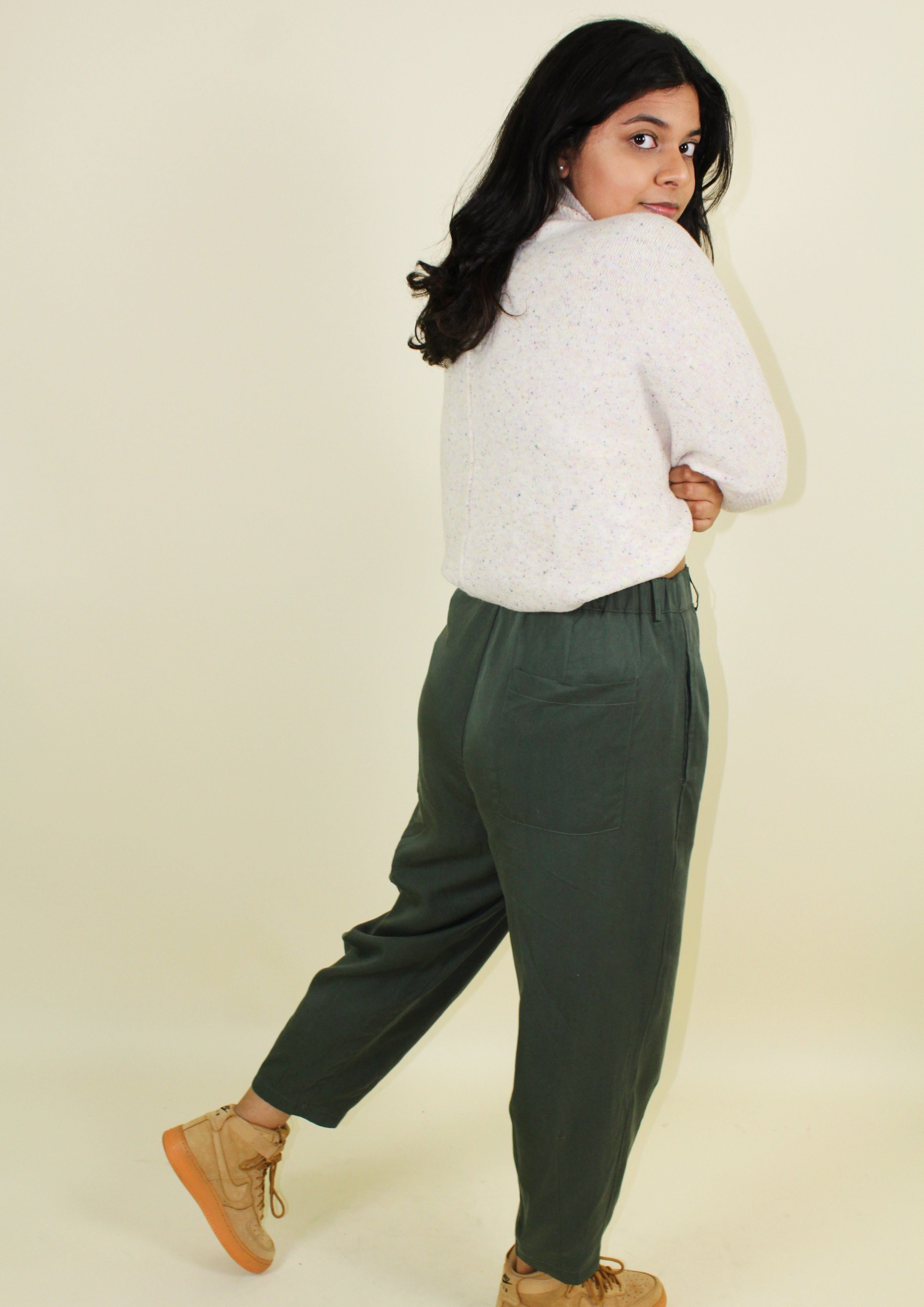 Loose fitting green trousers that taper in at the bottom. 