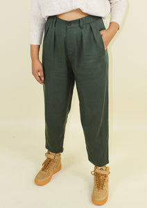 Loose fitting green trousers that taper in at the bottom. 